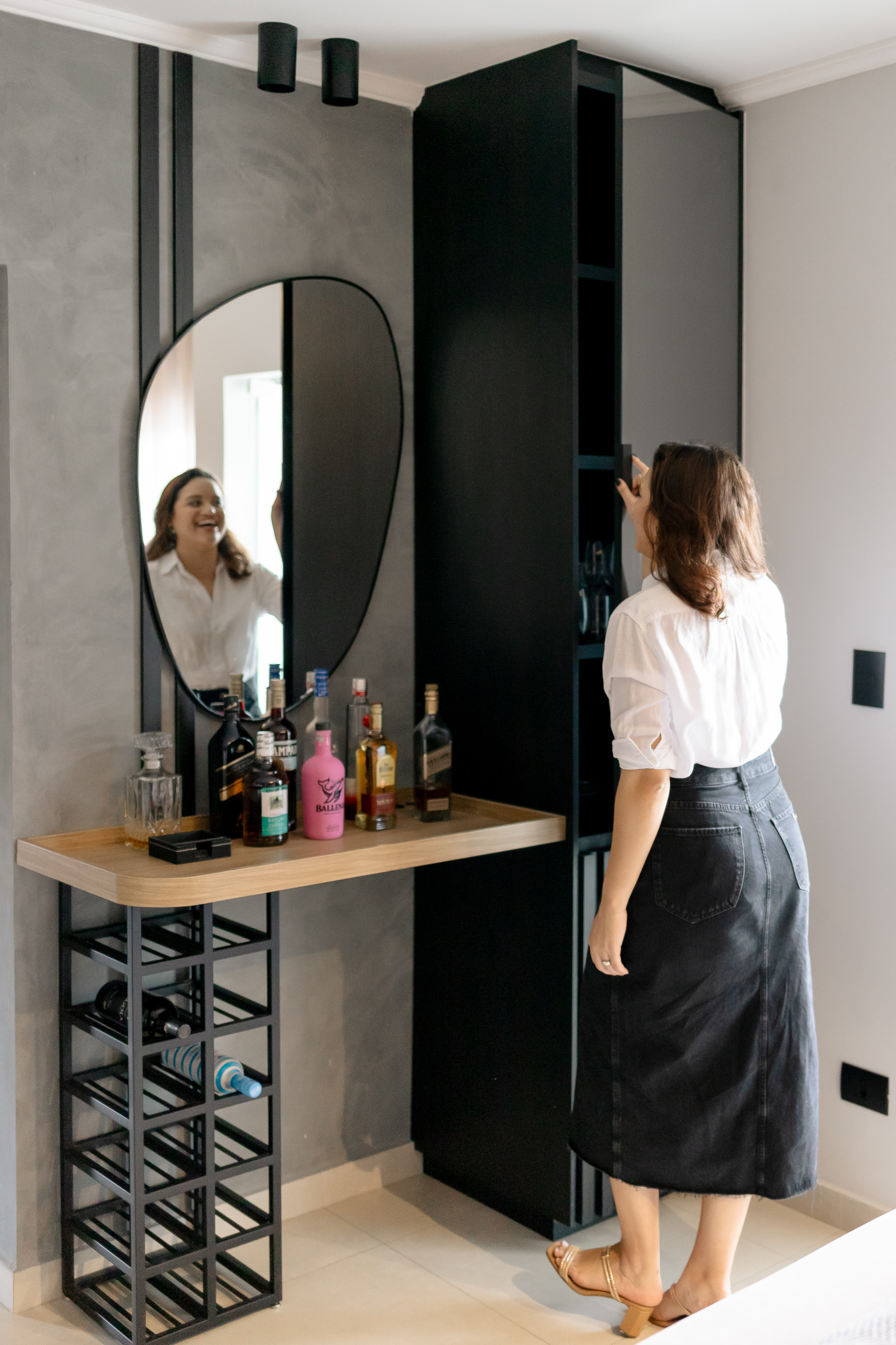 Quarto de hóspedes com cabeceira estofada cinza e iluminação aconchegante no projeto de interiores