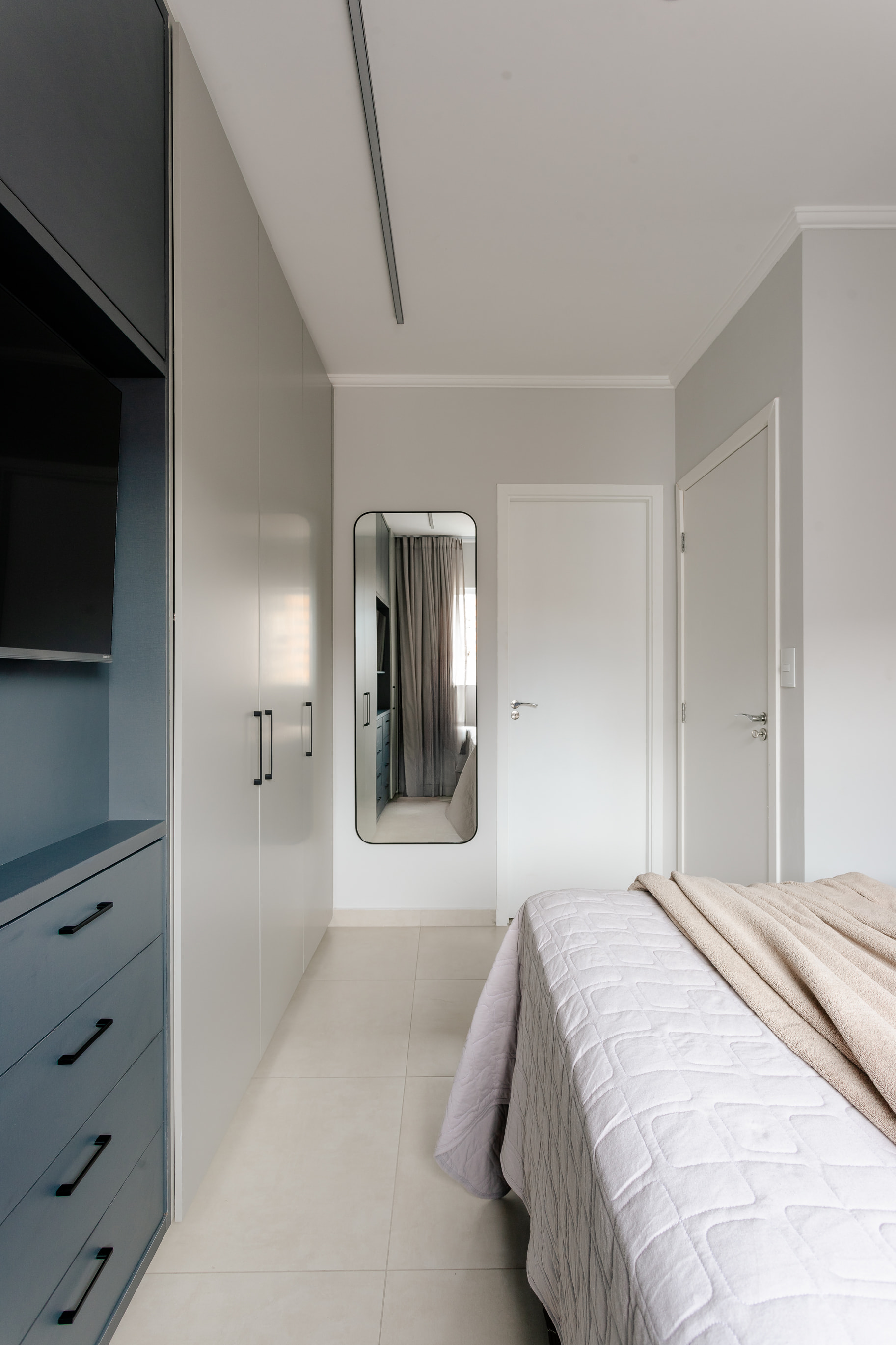 Cozinha moderna com eletrodomésticos embutidos e bancada escura em projeto de interiores