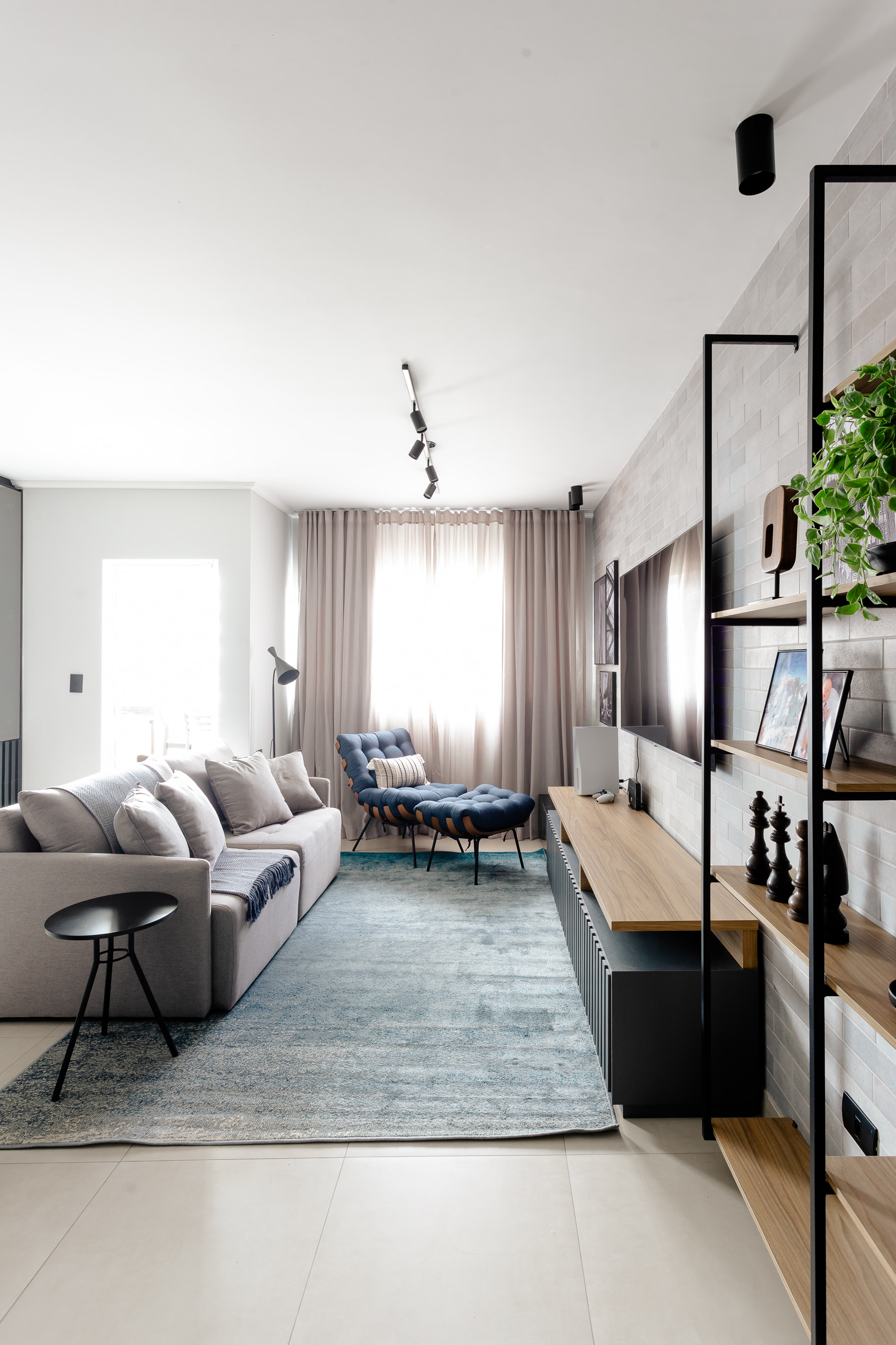 Parede de tijolinhos aparentes em sala de apartamento no estilo industrial contemporâneo